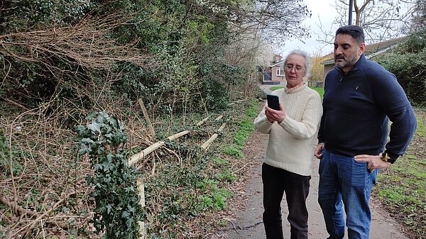 Lucy Care and Ajit Atwal reporting the broken down fence along side the A38