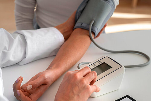 GP taking a patients blood pressure