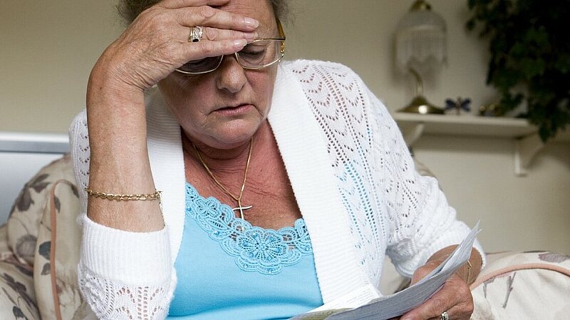 Woman looking concerned while reading a piece of paper